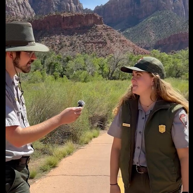 A ranger holds a microphone to another ranger