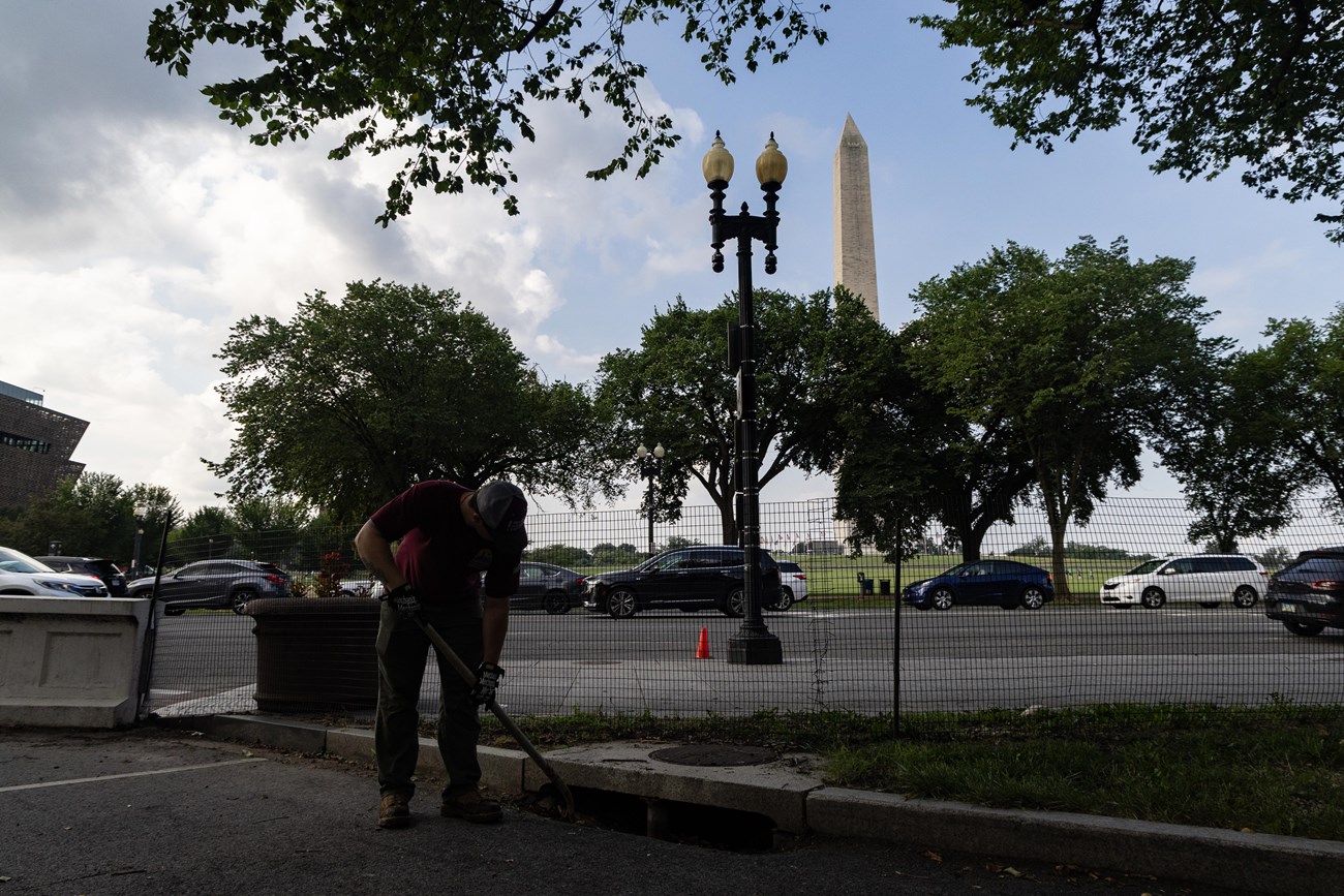 Traditional Trades Advancement Program (TTAP) intern Brenton Tate clears debris from a storm drain a