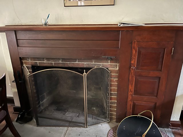 brick fireplace with wood mantlepiece that looks like cherry