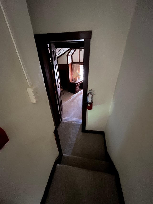 a hall and stairway showing the entrance to a bedroom