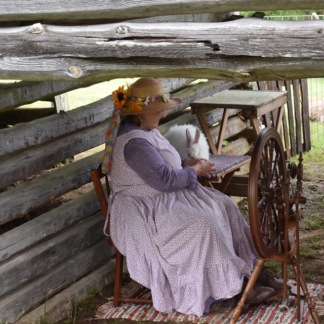 A woman sitting down on an old sewing machine.