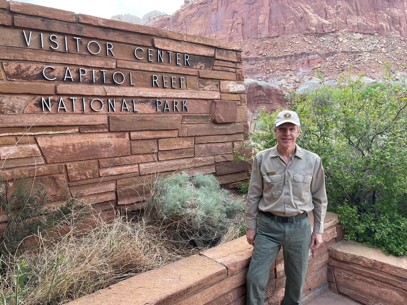 A volunteer stands next to the Capitol Reef National Park Visitor Center