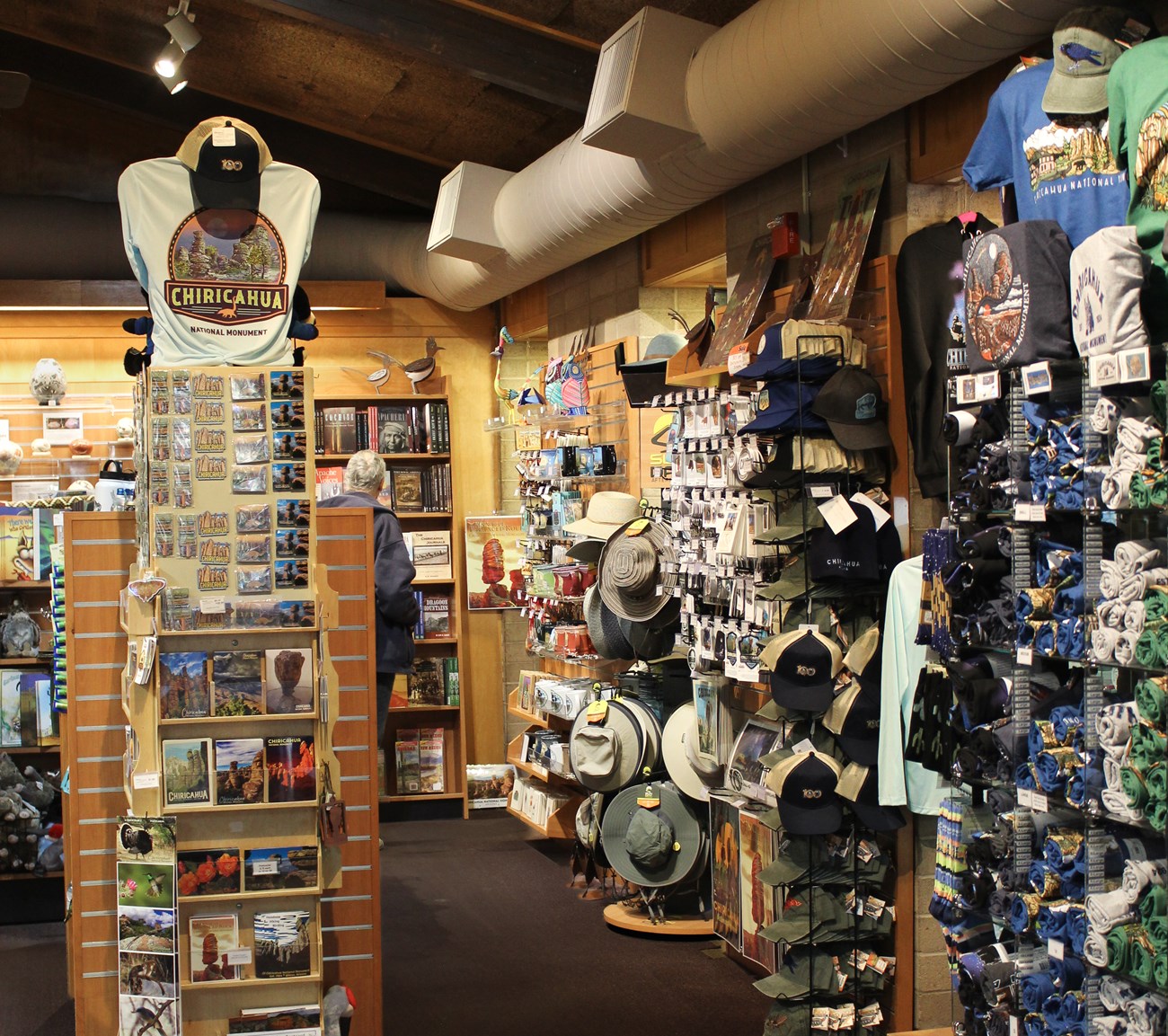 Shirts, hats, pins, magnets, and postcards in a store