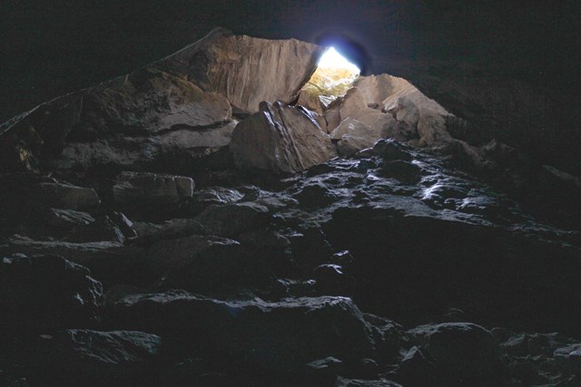 jagged rocks piled up lead to bright sunlight