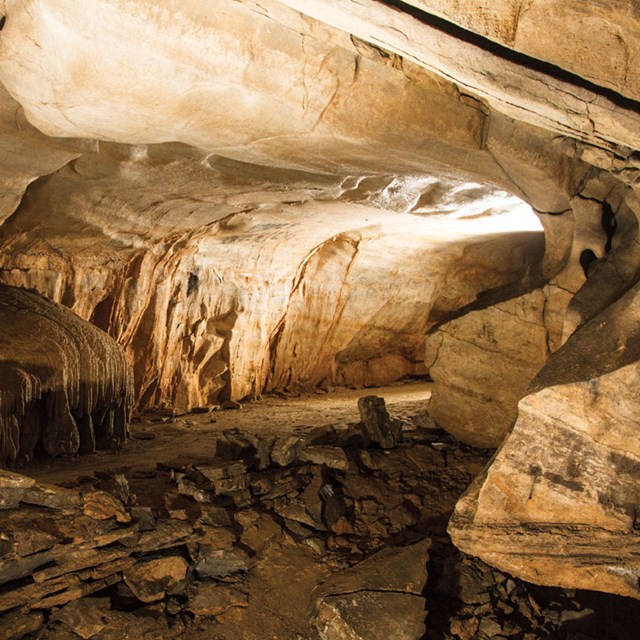 A section of the cave, featuring smooth rock formations and scattered stone slabs.