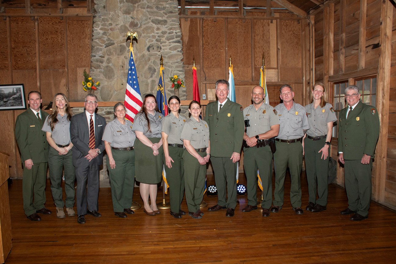 A large group of rangers pose for a photo in a log cabin.