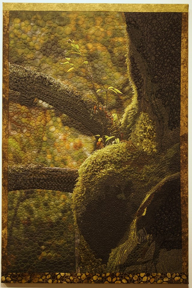 An absract art piece using texture and circles to create a tree like figure and rock.