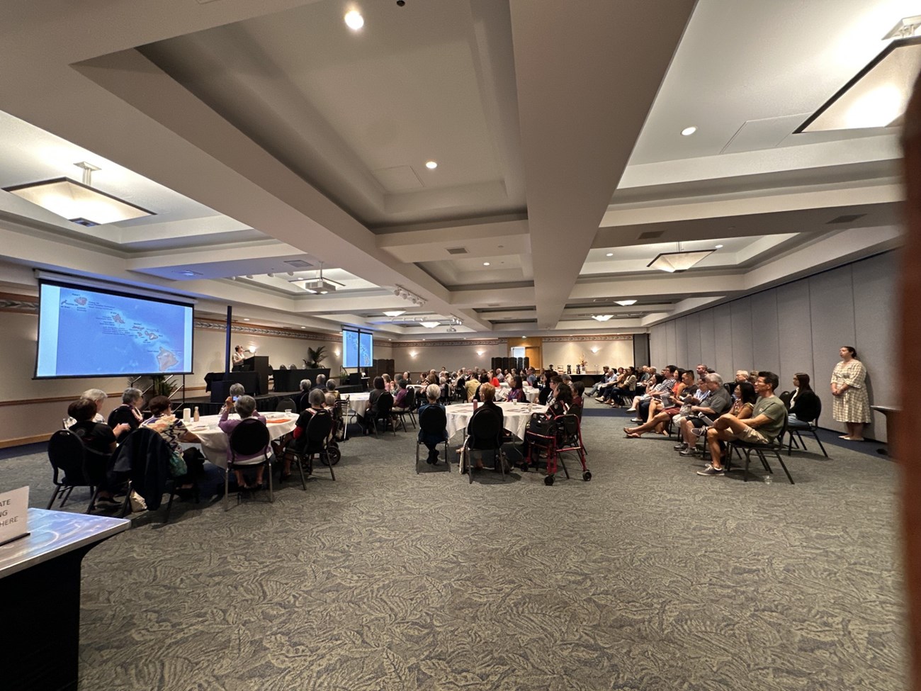 A large group of people sitting in a conference room.