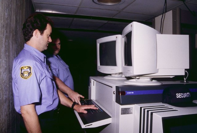 Two guards monitoring new Arch security system at Arch loading zone.