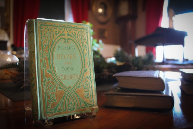 Green historic book propped up on a table