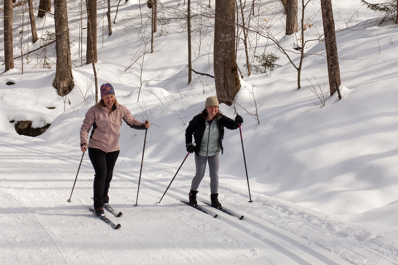 Two cross-country skiers on groomed snowy trail