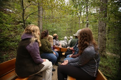Park Ranger talks to visitors on wagon ride through forest