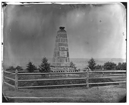 A Civil War photograph of a monument with hundreds of artillery shells lining it's base.