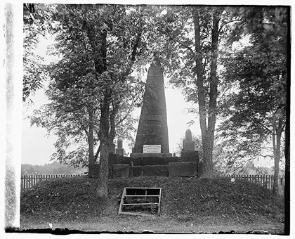 Patriots Monument in 1918 with overgrown trees and broken plaque.