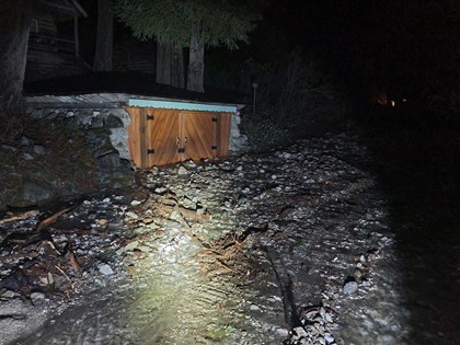 Two wooden panel doors buried in rocks, mud, and debris. The lower part of the door is covered.