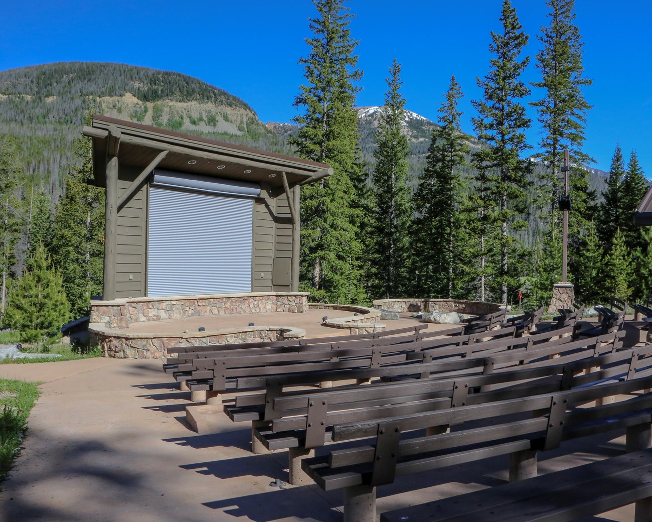 Amphitheater with wooden benches looking at a small stage.