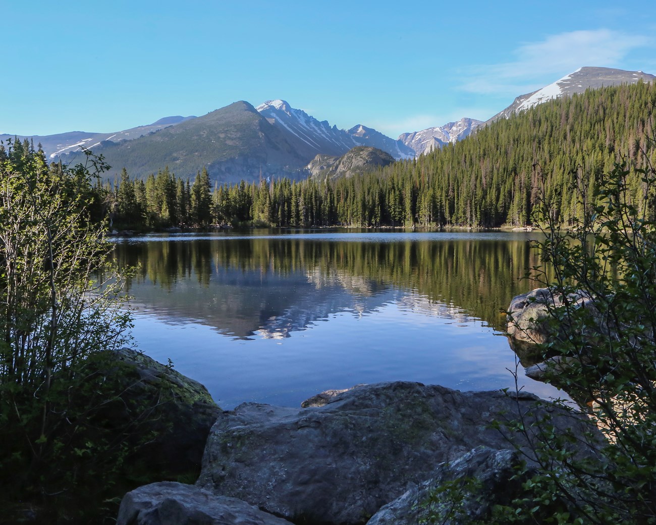 View of large between large boulders with mountains.