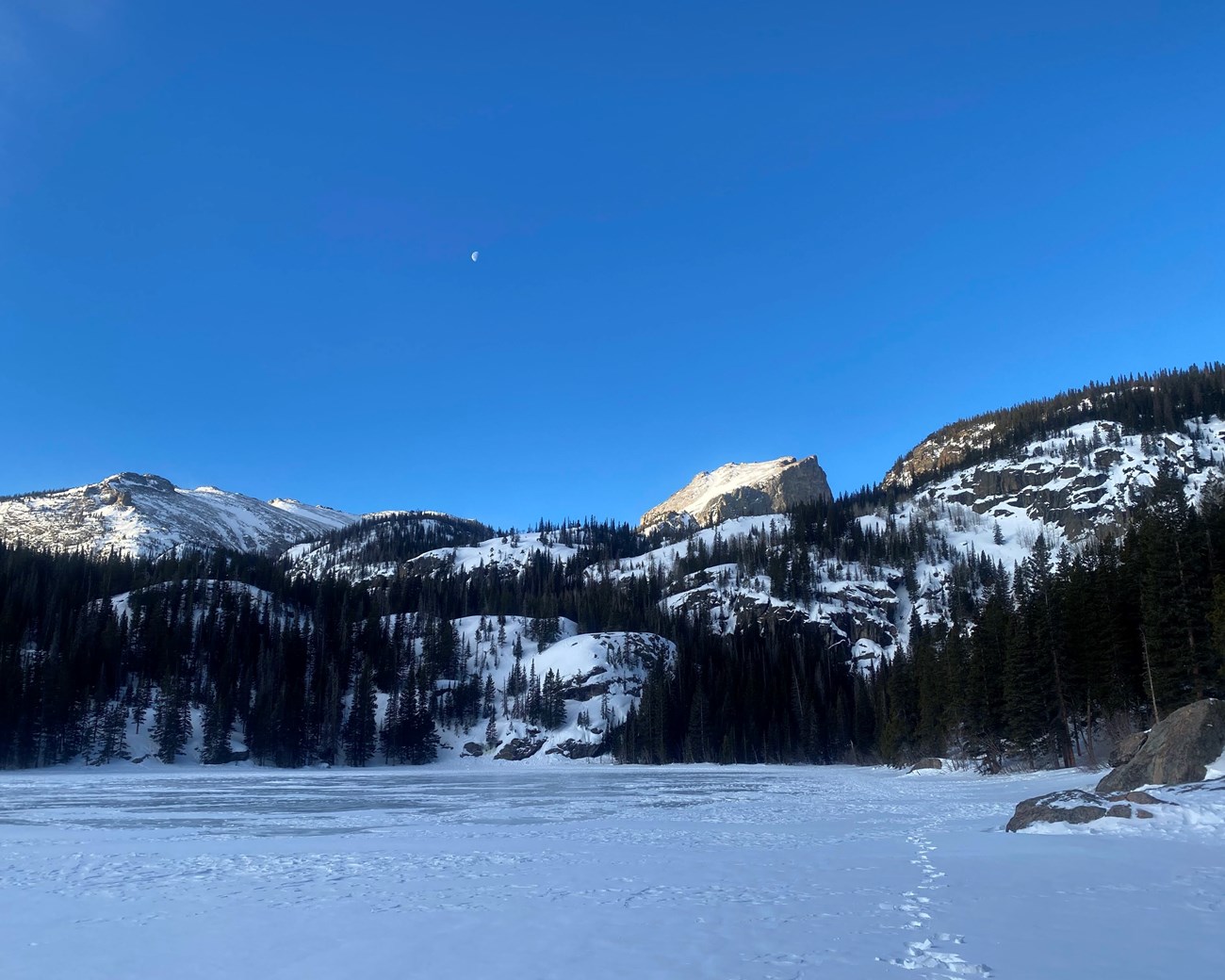 Frozen lake with snow covered mountains.