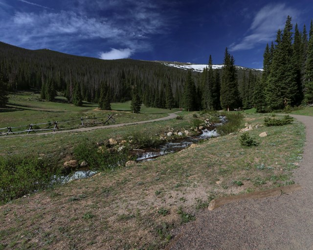 A creek surrounded by trails on both sides.