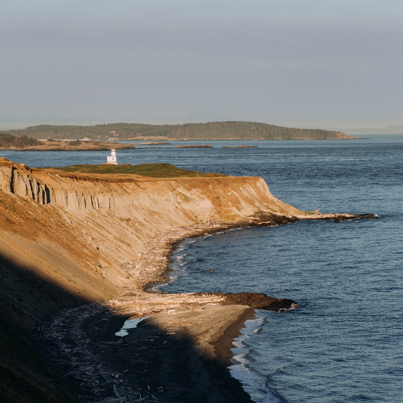 A white lighthouse on an ocean bluff