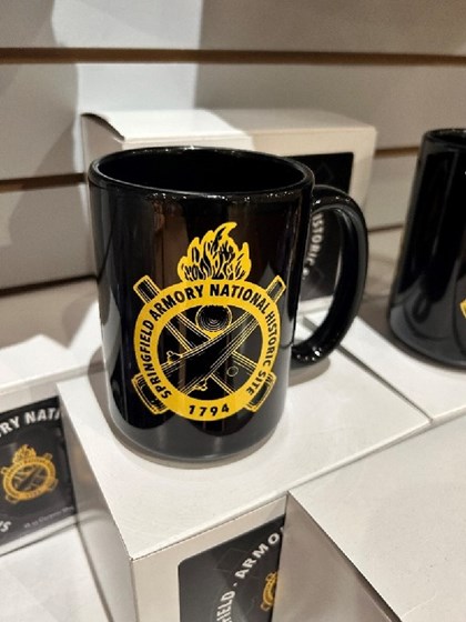 Picture of black coffee mug with yellow Ordnance Emblem.