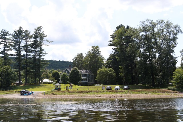 View of Lackawaxen River Access with Zane Grey Museum behind it. Kayakers are putting boat in river.