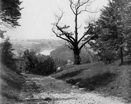 View from the top of hill on dirt road overlooking a river