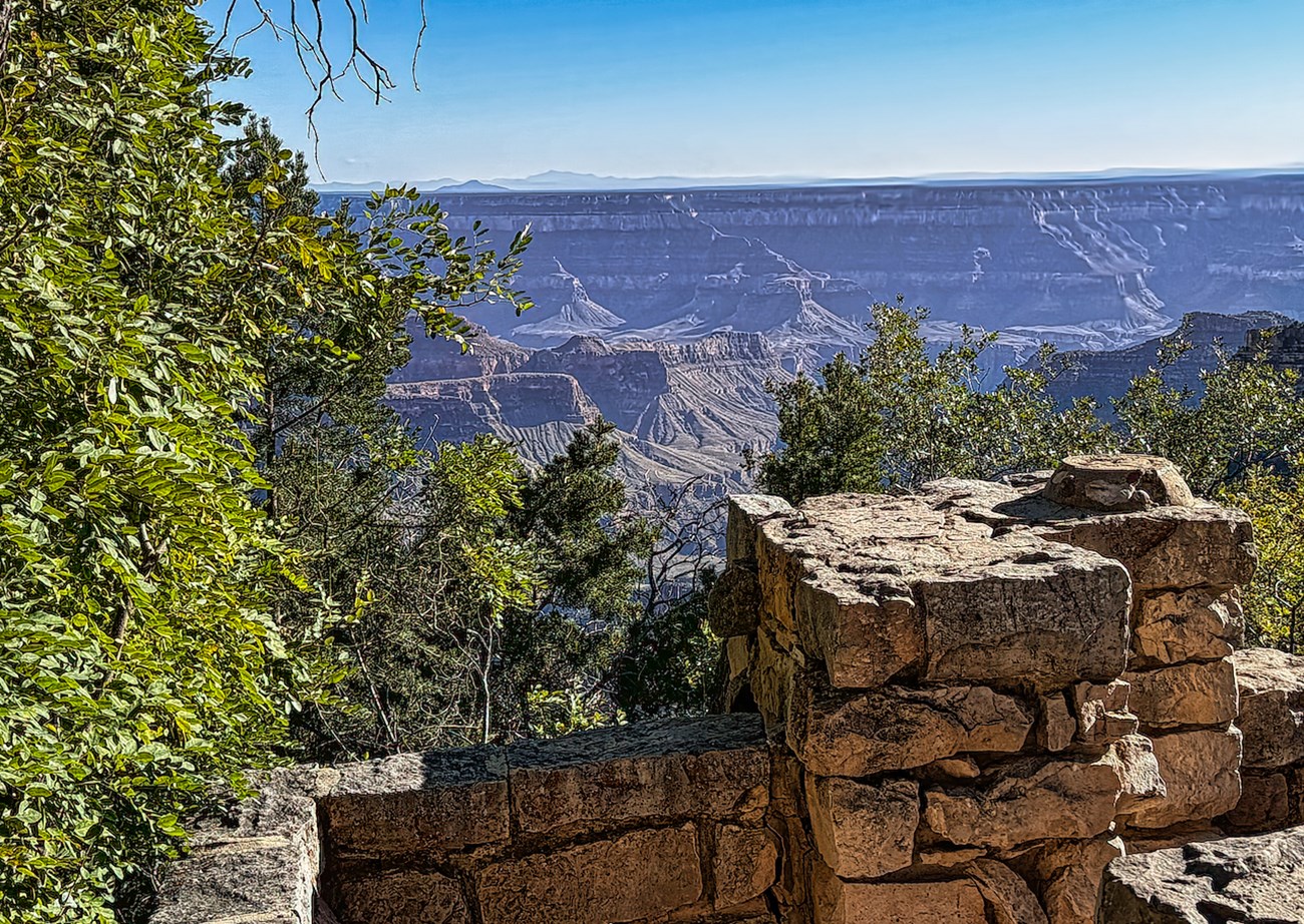 Man sitting on rock wall with canyon in background