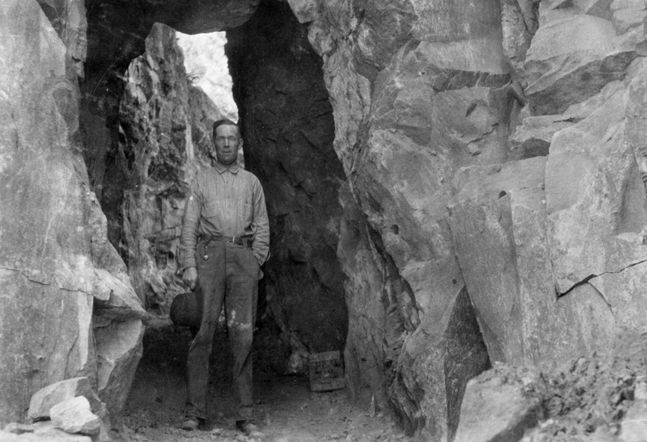 Man standing in tunnel carved through rock