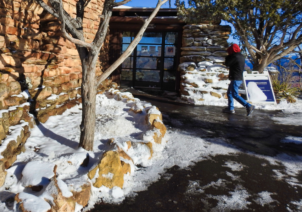 Park ranger speaking to group of people in front of stone building