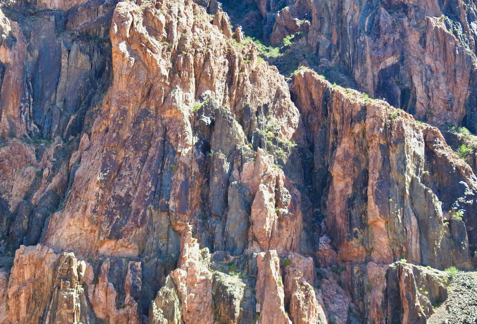 Helicopter carrying large pipe with cliff in background