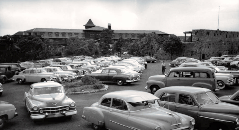 Multiple cars parked with buildings in background