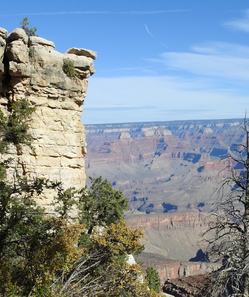 Woman standing on edge of cliff with canyon in background