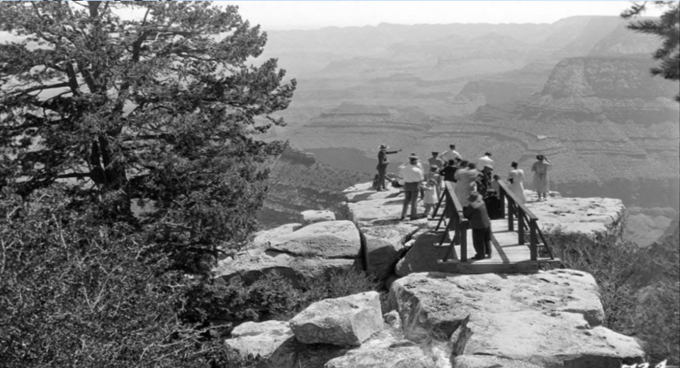 Cliff, bridge between rocks, people and trees
