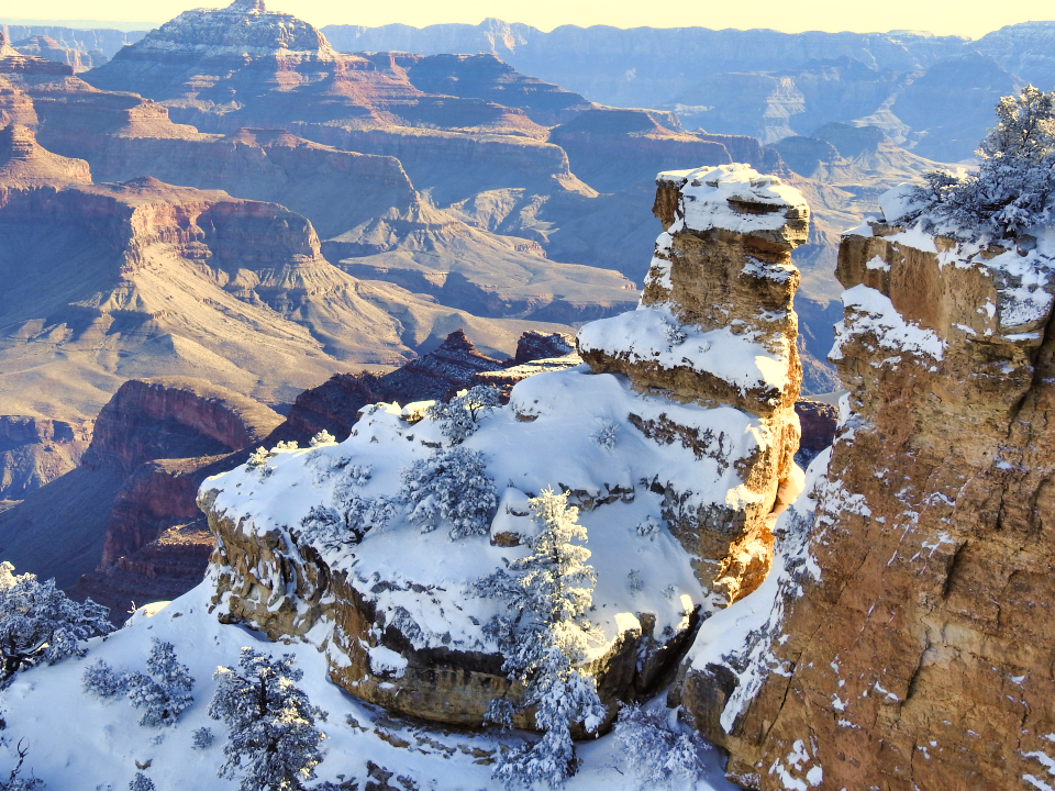 Painting of pinnacles and cliffs with snow and a tree