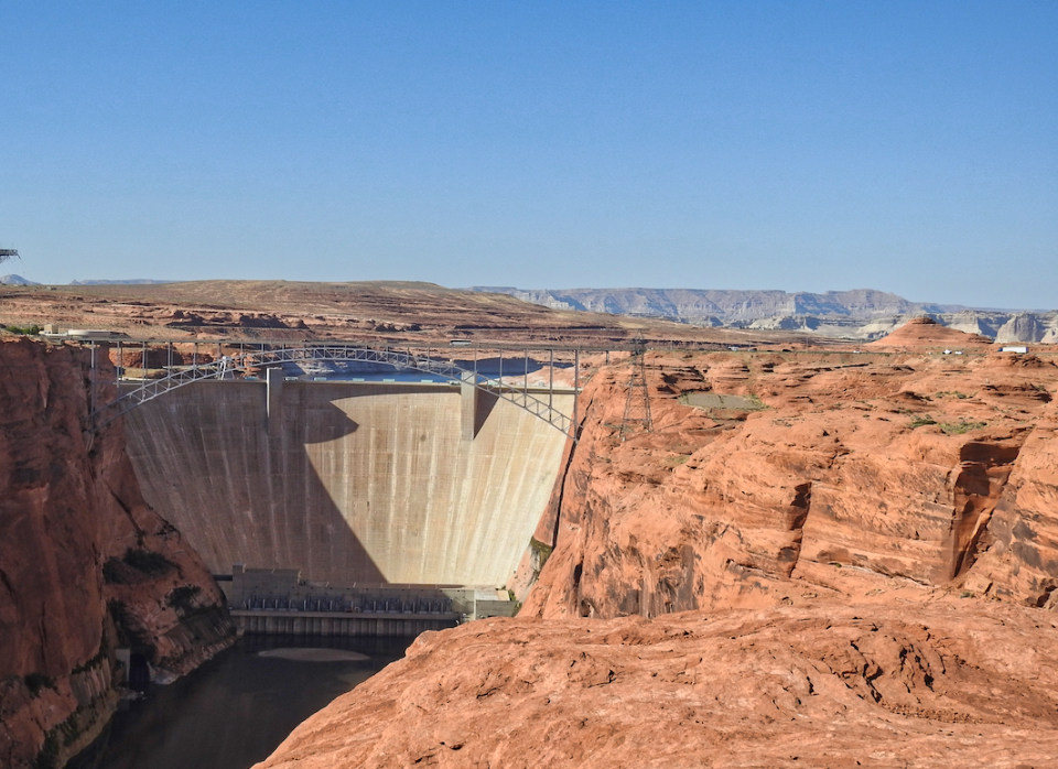 Painting of woman on horseback, a man and boy with dog in front of dam and river
