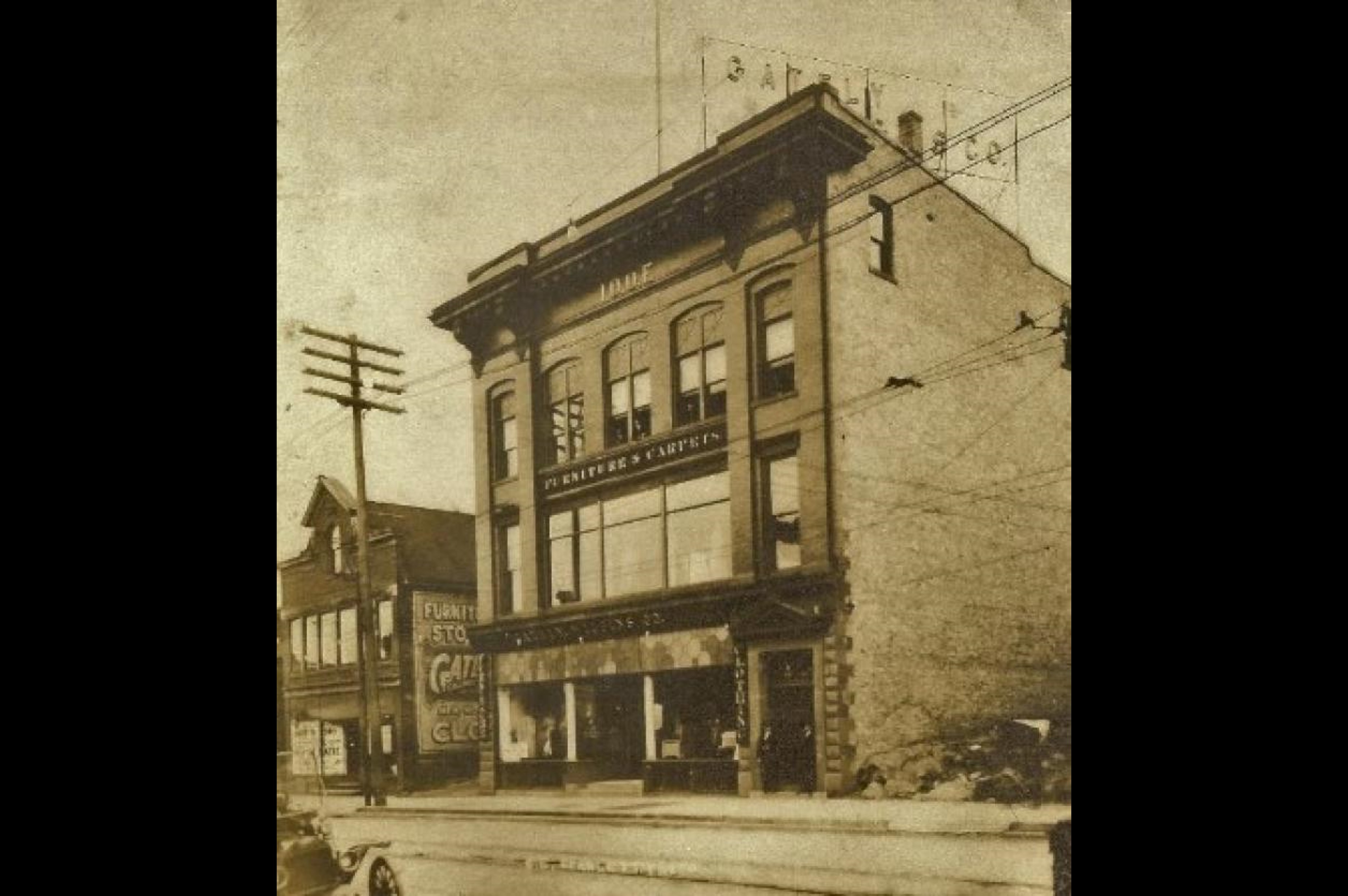 A historic black and white photo of the Oldfellows building in Houghton, MI