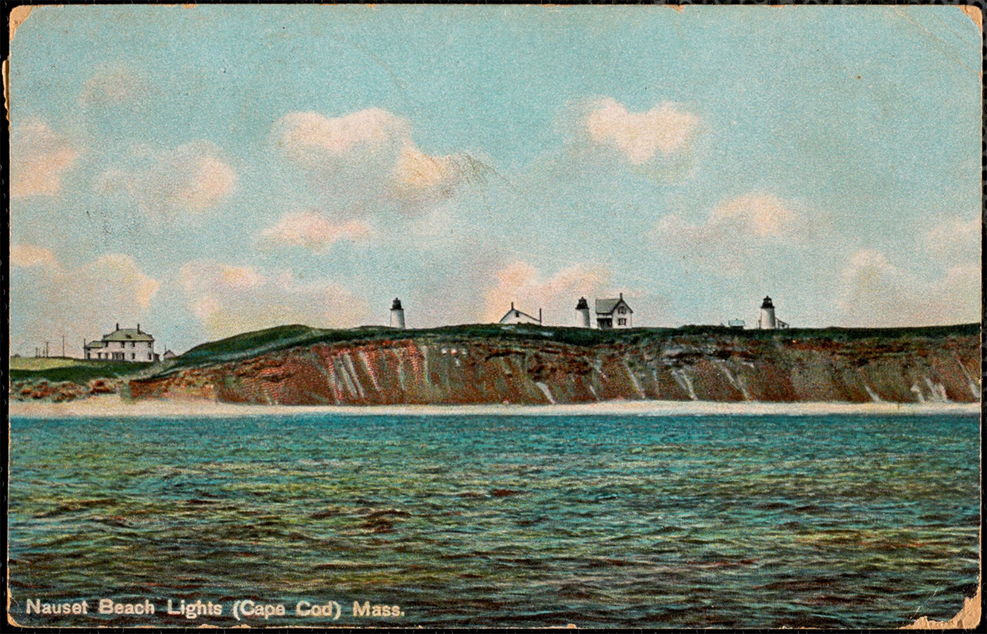 Three lighthouses are visible on a sea cliff.