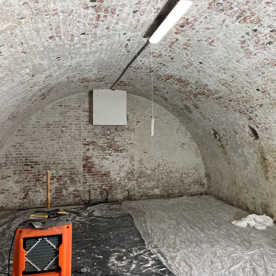 The interior of the bombproofs before the painting project, with paint peeling off the walls.