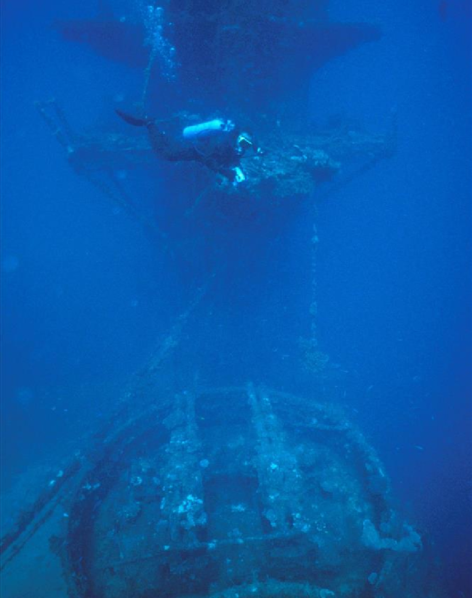 The top of an iron ship with guns mounted on the deck and command tower.
