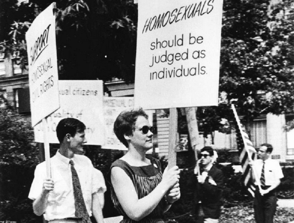 Photo of glass walled cafe that advertises donuts.