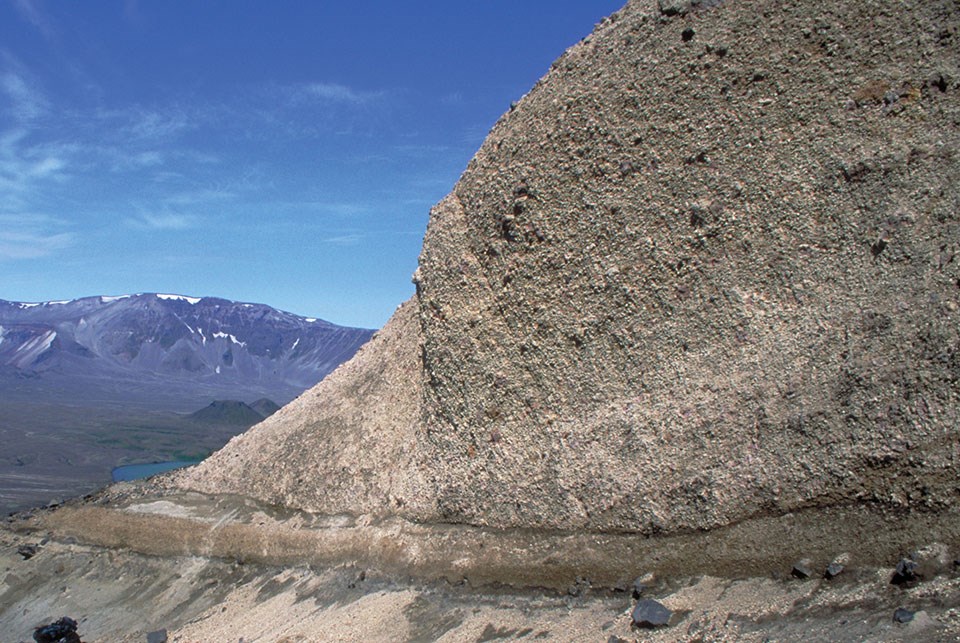 Photo of a rocky bluff with different layers of ash deposits