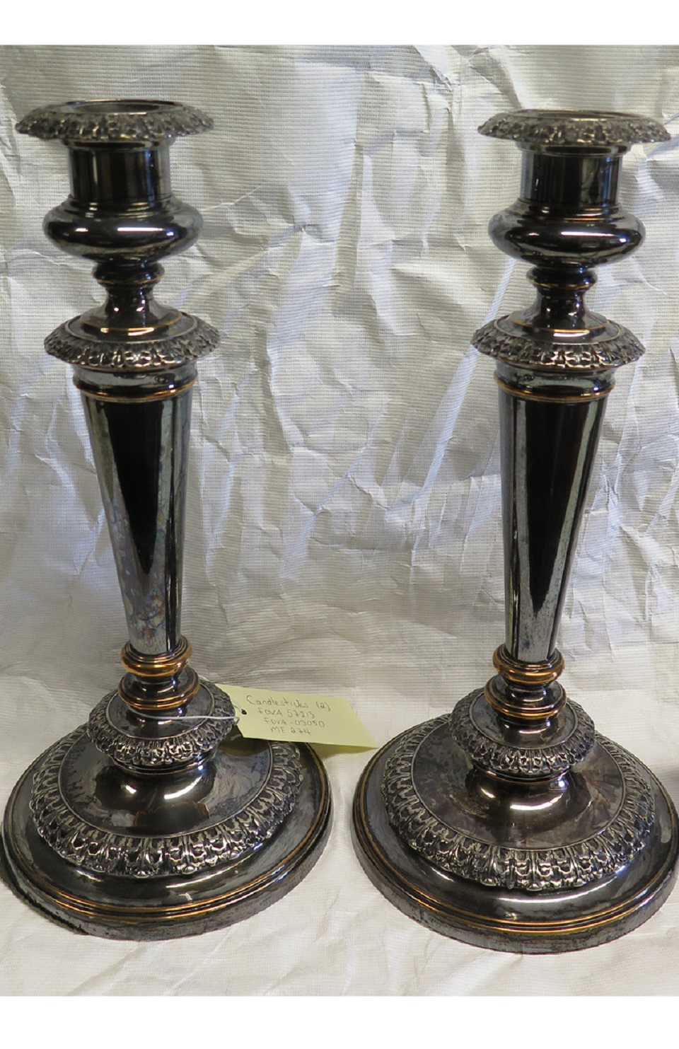 Two dark grey tarnished silver candlesticks.
