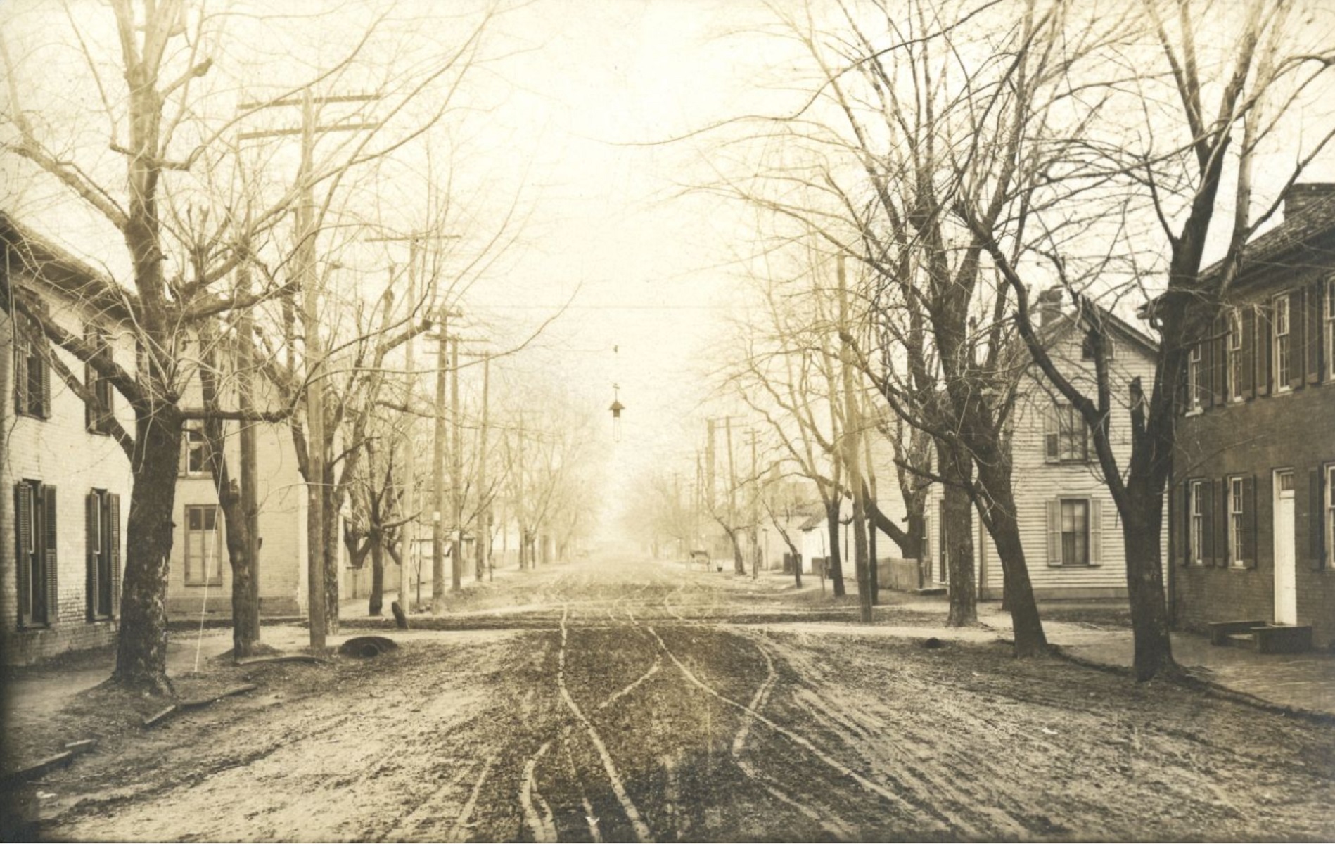 Family on a hillside overlooks a walled in town with all brick buildings and lots of towers