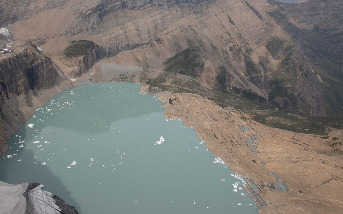 a bright blue lake with ice floating in it