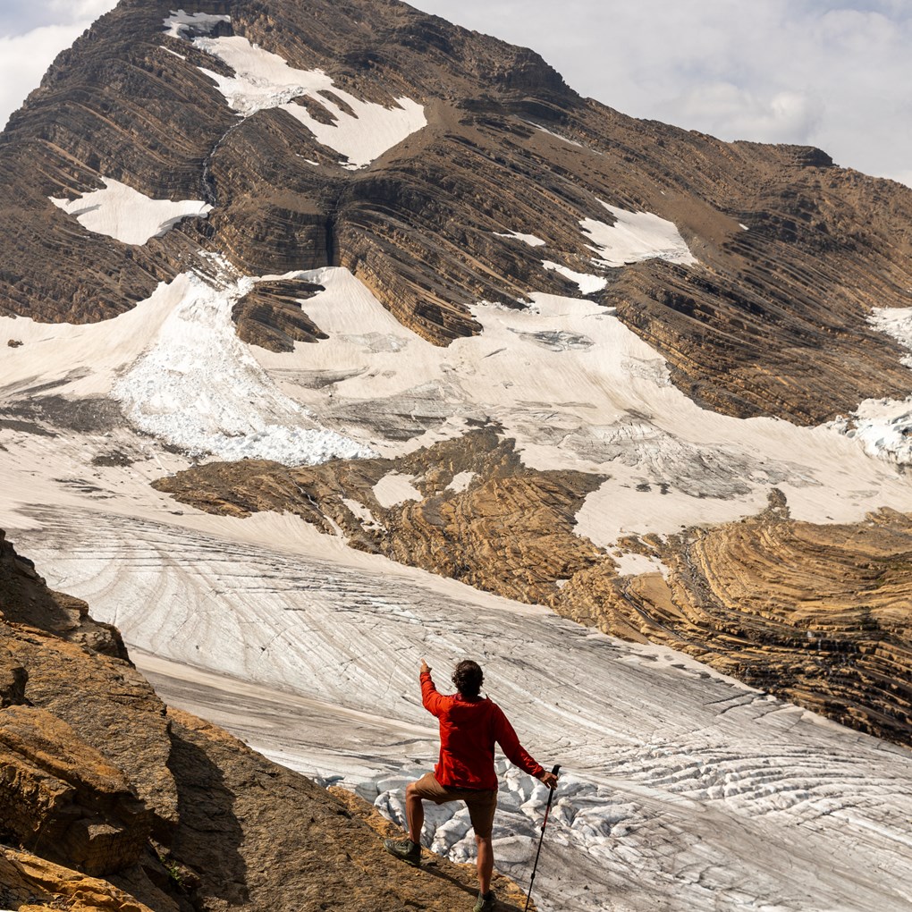 A square glacier landscape with a large mountain in the background and a person in the foreground.