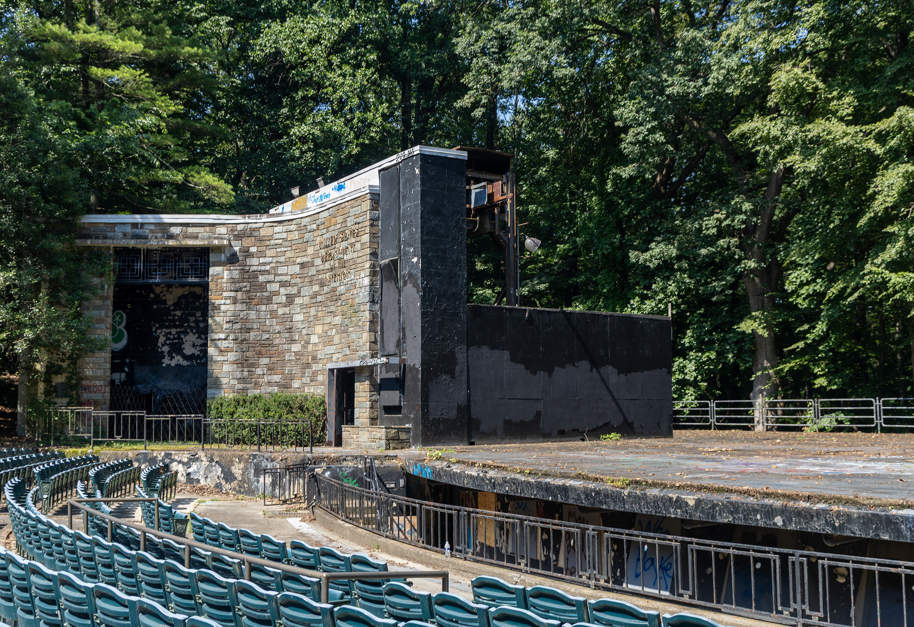 Seating at the Carter Barron Amphitheater with colorful graffiti on the stage walls.