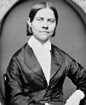 Black and white photograph of Lucy Stone wearing a dark jacket with white shirt and collar.