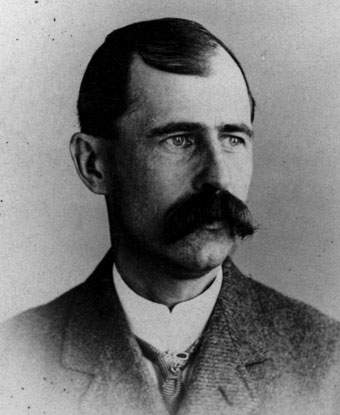 A man with a long and wide mustache wearing a suit
