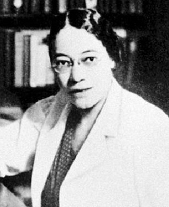 Head and shoulders portrait of a woman wearing a lab coat.